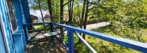 uma varanda com uma mesa sobre um corrimão azul em Pergolt Apartment em Pervalka