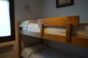 dwa łóżka piętrowe w pokoju z oknem w obiekcie Apartamento con jardín en la Cerdanya w mieście Err