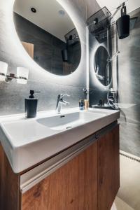 a bathroom with a white sink and a mirror at Apartman Othila , Apartman v Demanovskej doline in Liptovský Mikuláš