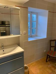 baño con lavabo y ventana en La Maison de Leontine, en La Livinière