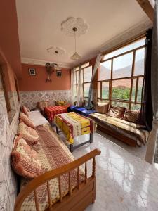 sala de estar con 2 camas y sofá en Dar Relax Hostel, Gorges de Todra, en Tinerhir