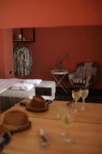 Cette chambre comprend un lit et une table avec des verres à vin. dans l'établissement CONTE CRISTO Suites, à Paralia Katerinis