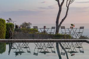 a table and chairs in the water next to a tree at Golfo dei Poeti Relais & Spa in Ameglia