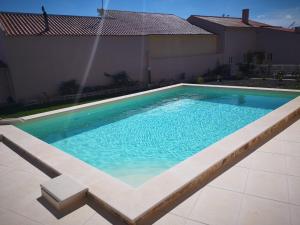 een zwembad met blauw water in een huis bij Feather House in São Bartolomeu