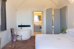 a bedroom with a bed and a tub and a bathroom at Ramo d'Aria Etna Boutique Hotel in Giarre