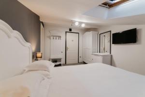 a bedroom with a white bed and a flat screen tv at Meteor Central in Cluj-Napoca