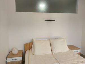 a bed with two pillows on it in a room at Apartmani Bambi Sokobanja in Soko Banja +22 photos