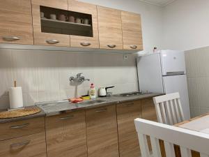 a kitchen with wooden cabinets and a white refrigerator at Apartmani Bambi Sokobanja in Soko Banja