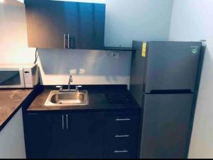 a small kitchen with a sink and a refrigerator at Departamento hermoso en guadalupe in Monterrey