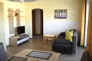 ein Wohnzimmer mit einem Sofa und einem TV in der Unterkunft Ferienwohnung Seethaler in Thiersee