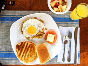 een bord ontbijtproducten met eieren, brood en fruit bij The Cottages by the Sea in San Clemente