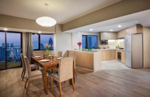 a kitchen and dining room with a table and chairs at Somerset Olympic Tower Tianjin in Tianjin