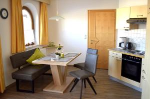 małą kuchnię ze stołem i krzesłami w pokoju w obiekcie Ferienwohnung Seethaler w mieście Thiersee