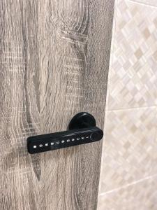 a black door handle on a shower door at Private Bathroom in King Room Bukit Mertajam Alma Impian in Bukit Mertajam
