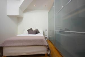 1 dormitorio con 1 cama y pared de cristal en Case VR Holiday Attico di Lino en Verona