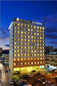 a lit up building with cars parked in a parking lot at Cititel Express Kota Kinabalu in Kota Kinabalu