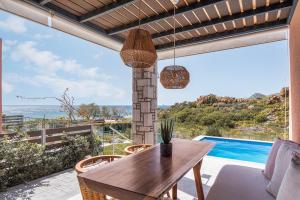 een eetkamer met een tafel en uitzicht op de oceaan bij Lemnosthea Luxury Residences in Agios Ioannis Kaspaka