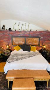 a large bed in a room with a brick wall at Valea Tătarilor in Lacu Rosu