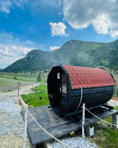 a black house with a red roof sitting on a track at Resort Valea Tătarilor in Lacu Rosu
