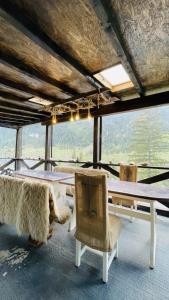 a table and chairs in a room with a view at Resort Valea Tătarilor in Lacu Rosu