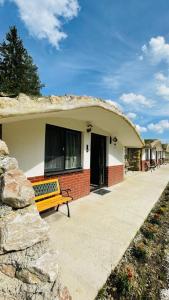 a yellow bench sitting in front of a house at Resort Valea Tătarilor in Lacu Rosu +42 photos