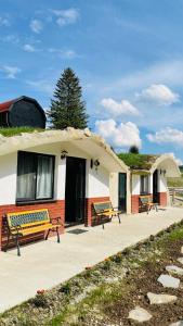 a building with benches in front of it at Resort Valea Tătarilor in Lacu Rosu