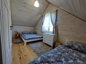 een slaapkamer met 2 bedden en een raam in een kamer bij Domek Mani in Trześcianka