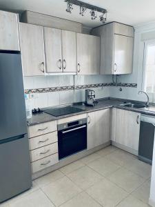 a kitchen with stainless steel appliances and white cabinets at Fresh apartment, 2 bedroom, 2 bathroom, 2 lovely poolareas in Los Alcázares