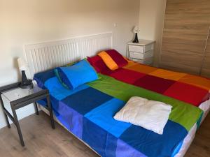 een slaapkamer met een bed met een kleurrijke deken bij La Hayuela in Ayuela
