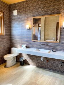 a bathroom with a sink and a toilet and a mirror at Maquil Hotel and Villas in Zipolite