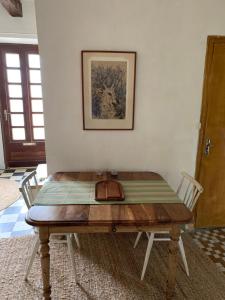 a wooden table in a room with two chairs at stylish one bedroom apartment in a lovely village in Saint-Vincent-Rive-dʼOlt