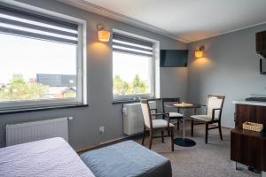 a room with a bed and a table and chairs at Villa Luka in Łeba