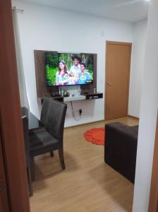 a living room with a flat screen tv and a chair at AP confortável para sua família in Palmas