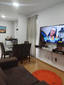 uma sala de estar com uma grande televisão de ecrã plano na parede em AP confortável para sua família em Palmas