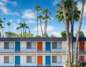 um exterior de um hotel com palmeiras em The Sojourn Los Angeles - Sherman Oaks em Sherman Oaks