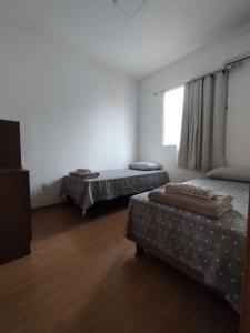 a room with two beds and a window at AP confortável para sua família in Palmas