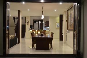 a dining room and kitchen with a table and chairs at The Arnaya in Kuta