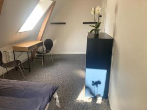 a room with a desk and a table with a vase of flowers at Residens Svalhøj in Hasle