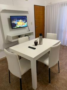 a white dining room table with white chairs and a tv at Fenix 2 in Colón