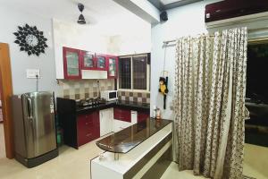 a kitchen with red cabinets and a stainless steel refrigerator at Alibaug Castle Villa in Nagaon +8 photos