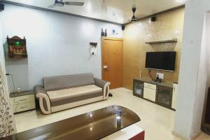 a living room with a couch and a tv at Alibaug Castle Villa in Nagaon