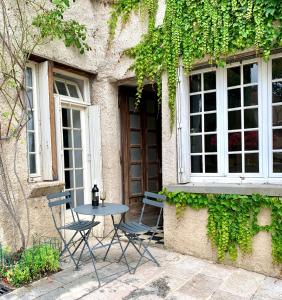 a table and chairs in front of a building at stylish one bedroom apartment in a lovely village in Saint-Vincent-Rive-dʼOlt +3 photos