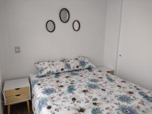 a bedroom with a bed with a floral bedspread at Hermoso departamento Cerro los placeres Valparaíso in Valparaíso