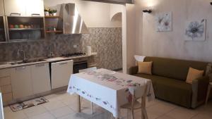 kuchnia i salon ze stołem i kanapą w obiekcie LA DIMORA DI MARIA w mieście Ortona