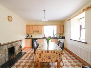 a kitchen with a table and a fireplace at Tilladavin House in Tomhaggard