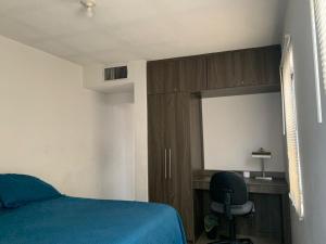 Schlafzimmer mit einem Bett, einem Schreibtisch und einem Stuhl in der Unterkunft Zona nuevo CAMPUS Universidad departamento independiente in Chihuahua
