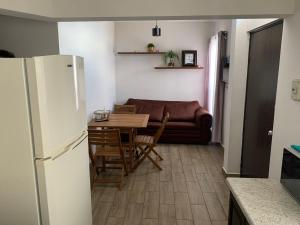 eine Küche mit einem Kühlschrank, einem Tisch und einem Sofa in der Unterkunft Zona nuevo CAMPUS Universidad departamento independiente in Chihuahua