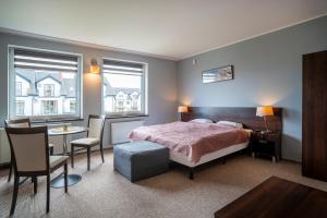 a bedroom with a bed and a table and chairs at Villa Luka in Łeba