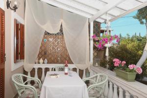 einen weißen Tisch und Stühle auf einem Balkon mit Blumen in der Unterkunft Olive Tree Cottage in Virós