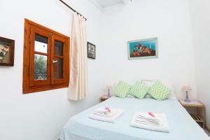 ein Schlafzimmer mit einem Bett mit zwei Handtüchern darauf in der Unterkunft Olive Tree Cottage in Virós